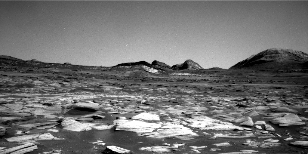 Enlarged rover view with rough foreground rocks and subtle tonal contrasts on the slopes ahead.